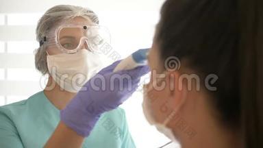 护士戴着医用口罩和眼镜，用非接触式红外温度计测量病人`体温。